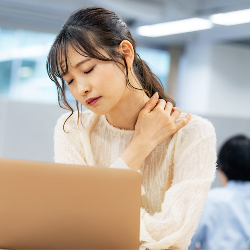 パソコンの仕事で肩こりがひどい様子の女性